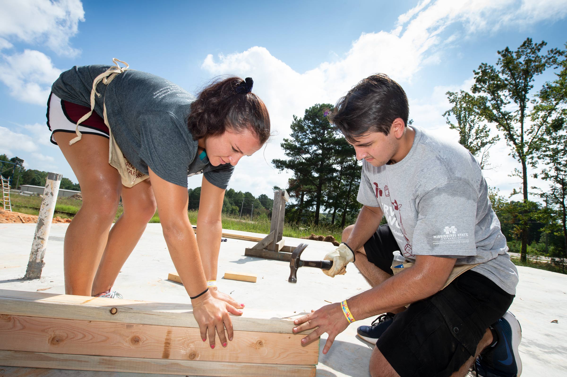 Student Service Dawgs Day Volunteers Amanda Wilson and Garrett Reeves hammer together wall framing at the Habitat for Humanity House.
