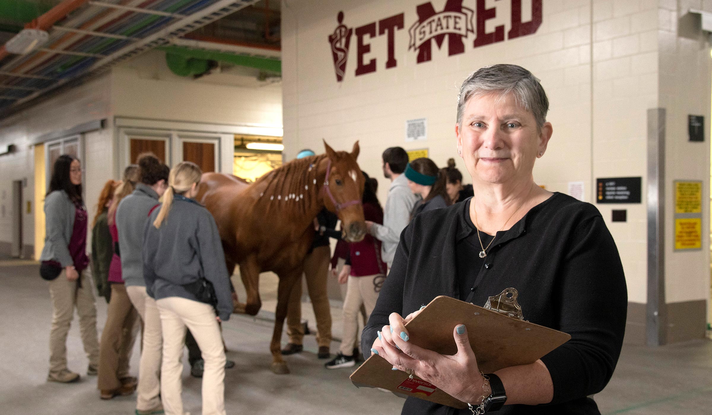 Pauline Prince, pictured in front of a horse and veterinary students.