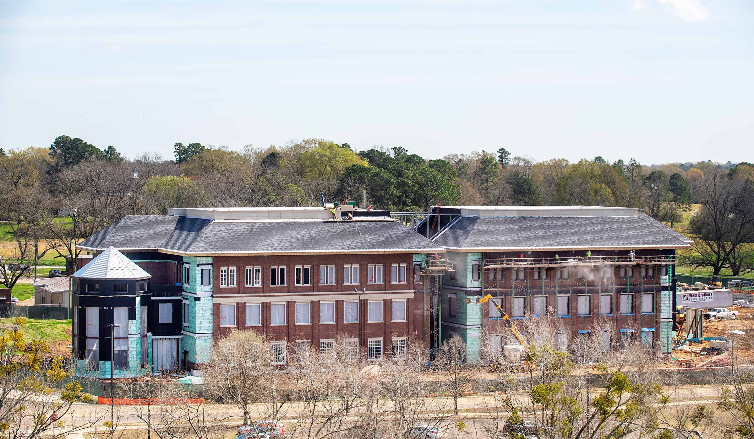 Wide view from high vantage point of building under construction with partial brick facade in place