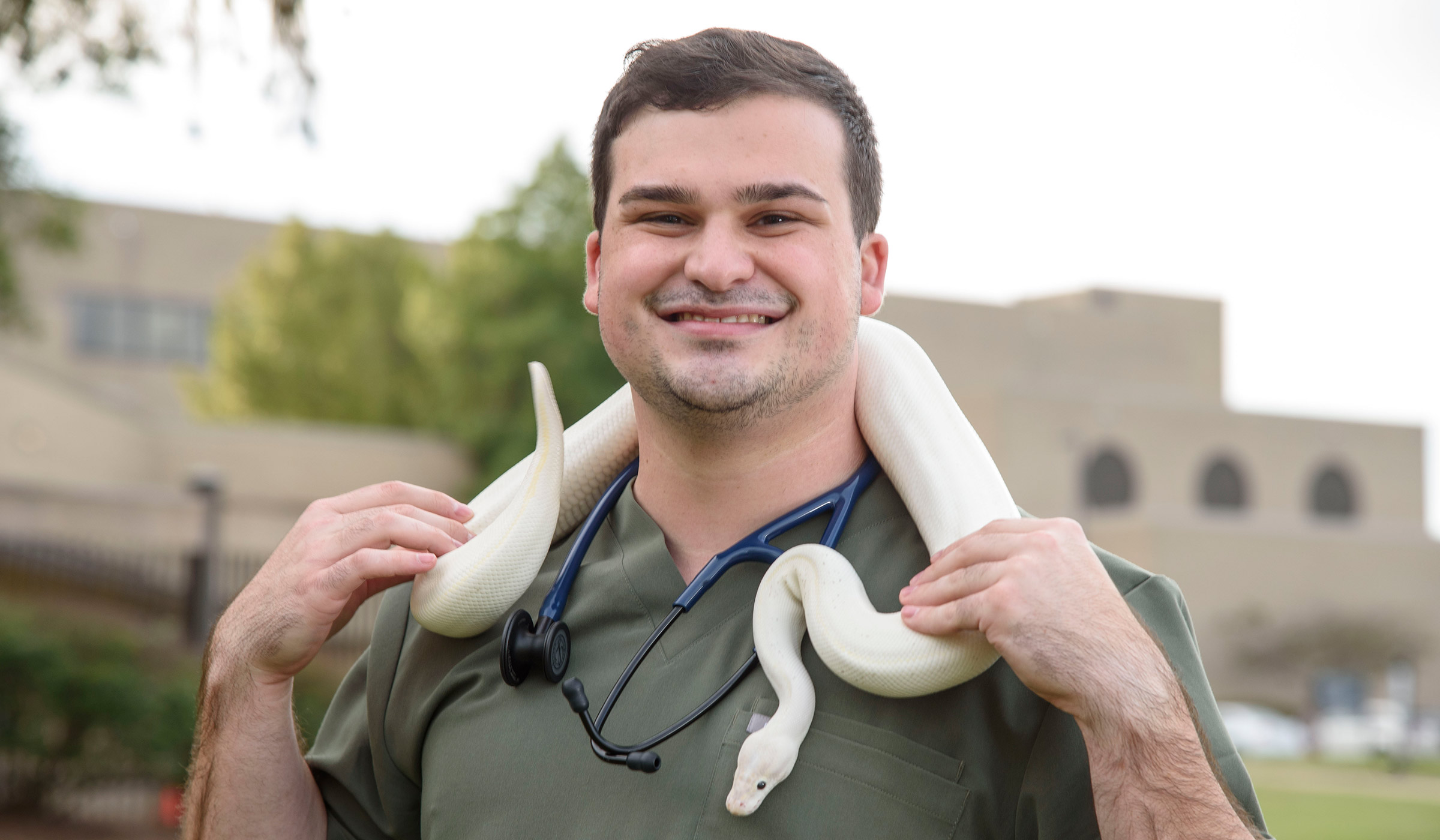 Travis Noto, pictured with a pet snake draped over his shoulders.