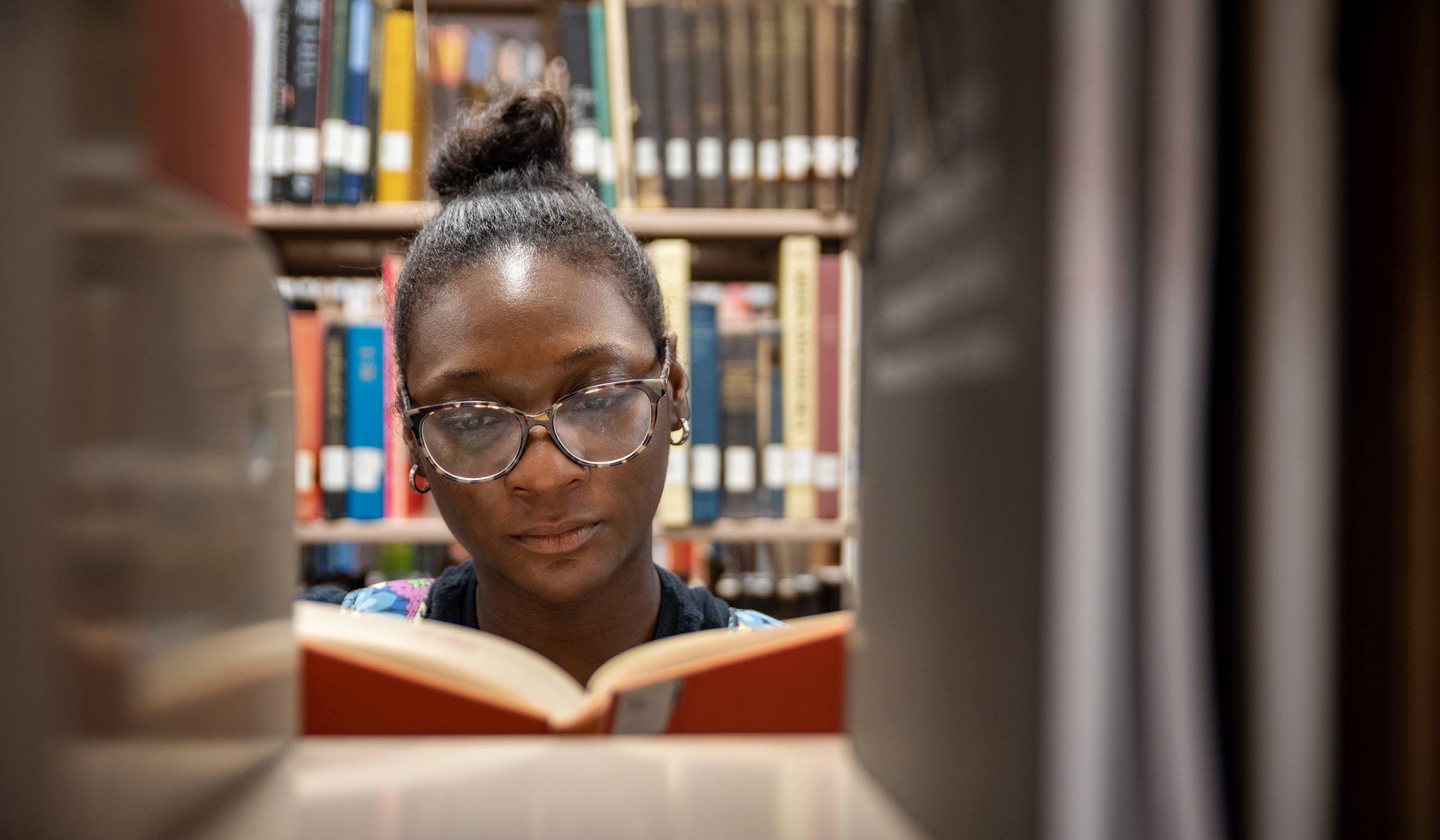 Female student in library looking at book