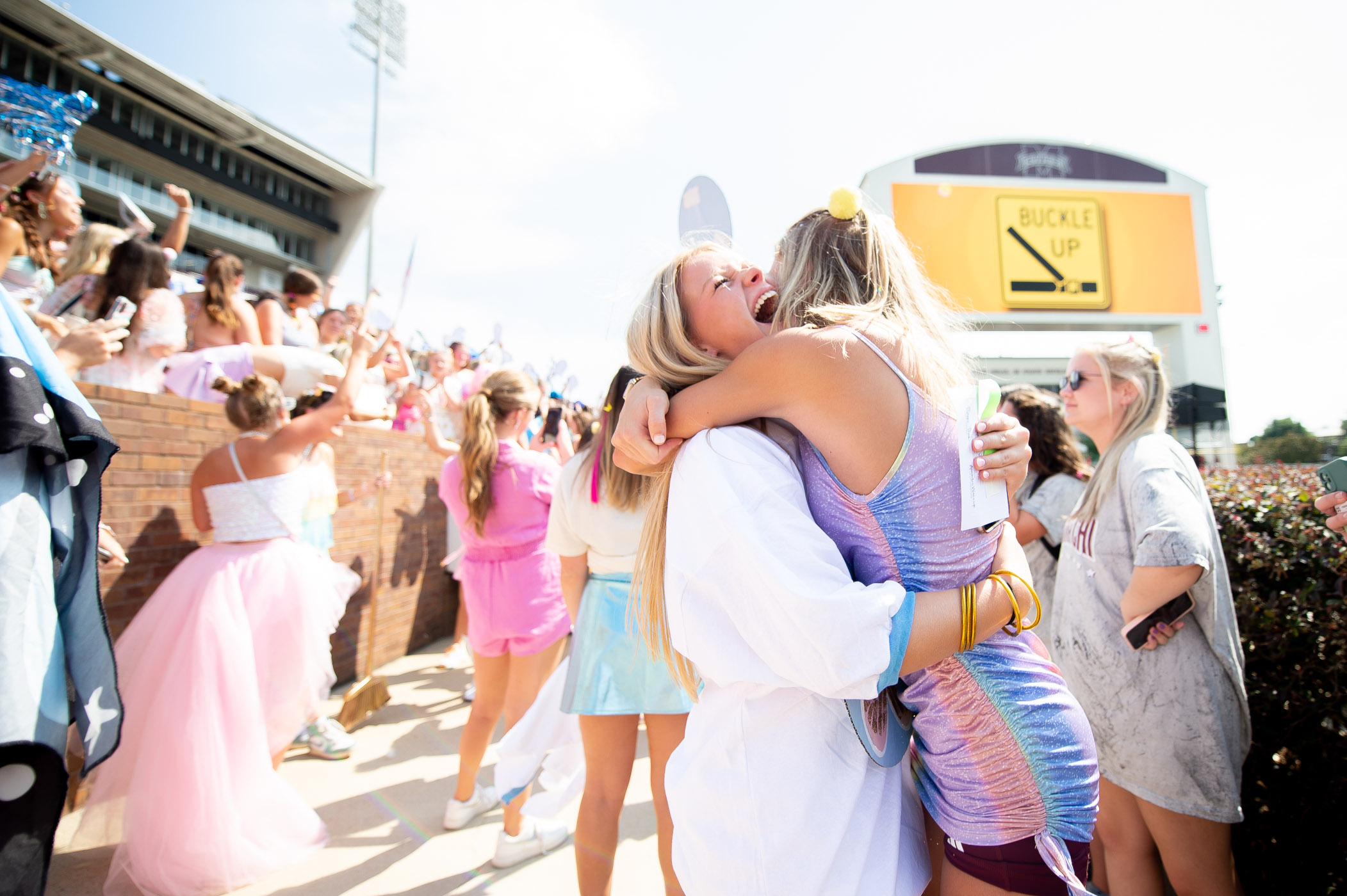 Two new &quot;sisters&quot; of MSU&#039;s chapter of Delta Gamma embrace with joy upon arrival to Davis Wade Stadium
