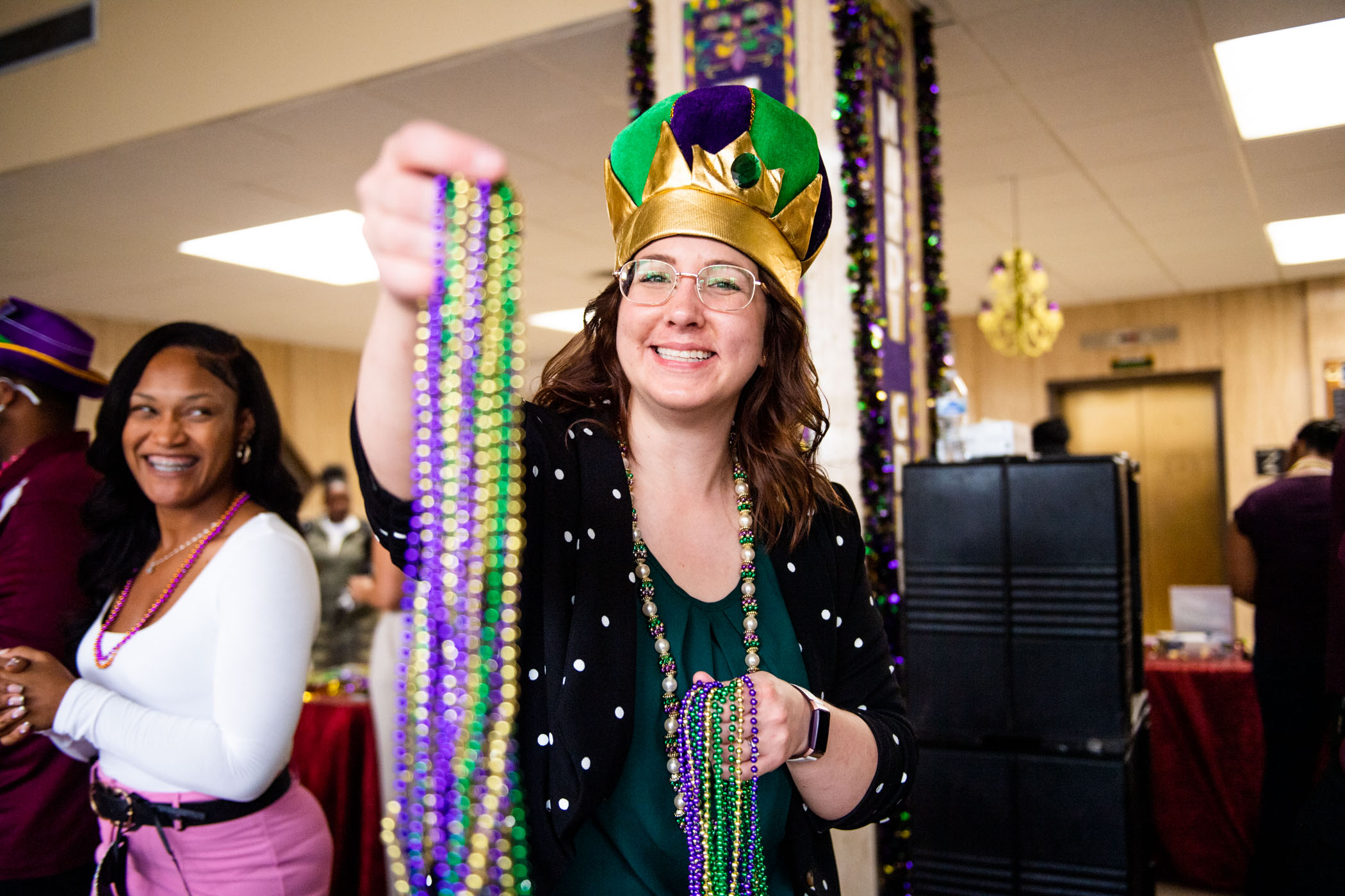 Lilli Harris, Grad Student Development Coordinator at MSU's Graduate School, holds out colorful beads- a long time Mardi Gras tradition, for a photo.