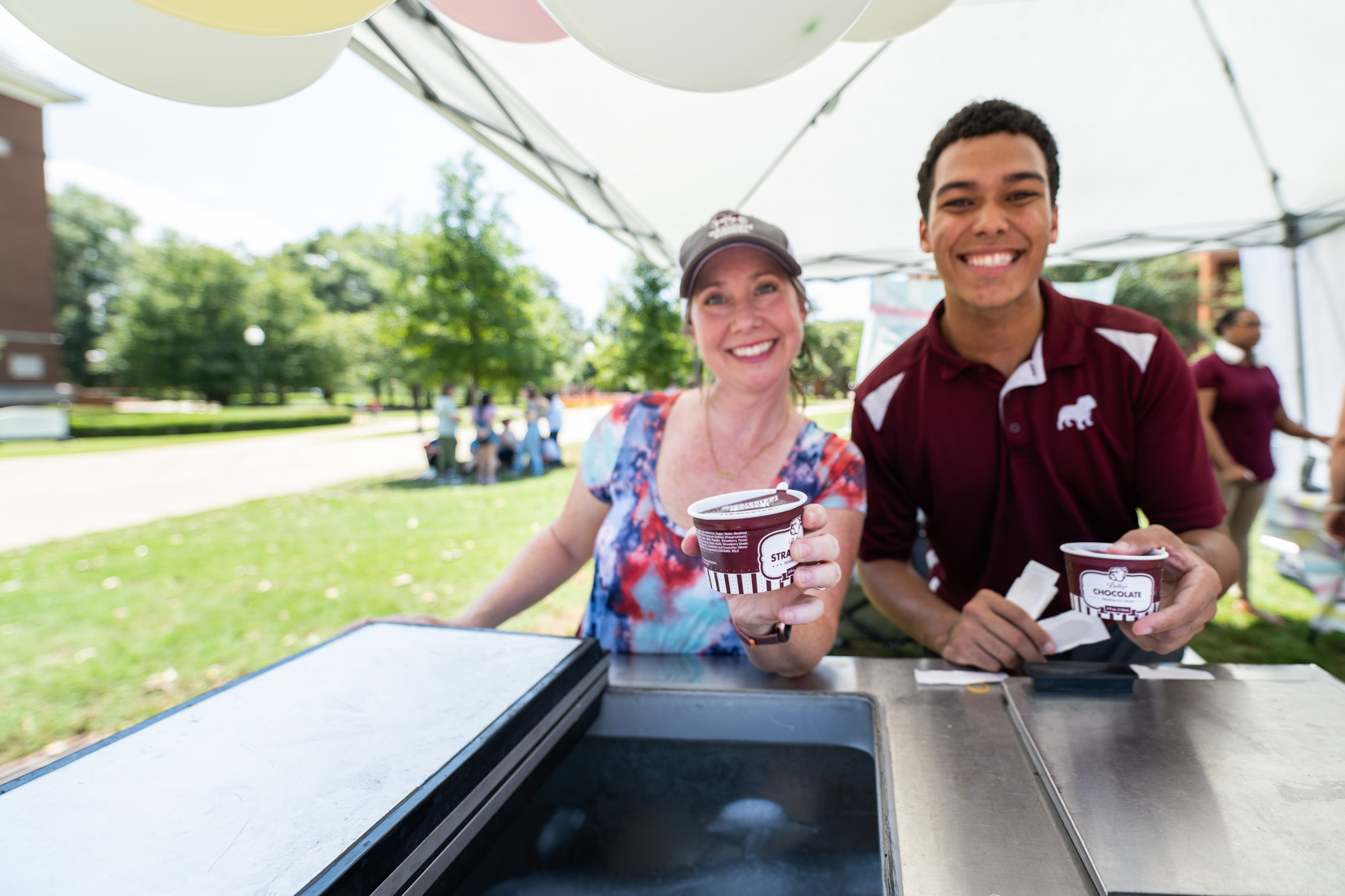 Lindsey Shelton and Tyrone Tolbert Jr., staff at The Graduate School at MSU, hand out Bully&#039;s Ice Cream to partakers in the department&#039;s free ice cream social on the Drill Field, the perfect remedy to Starkville&#039;s summer heatwave.