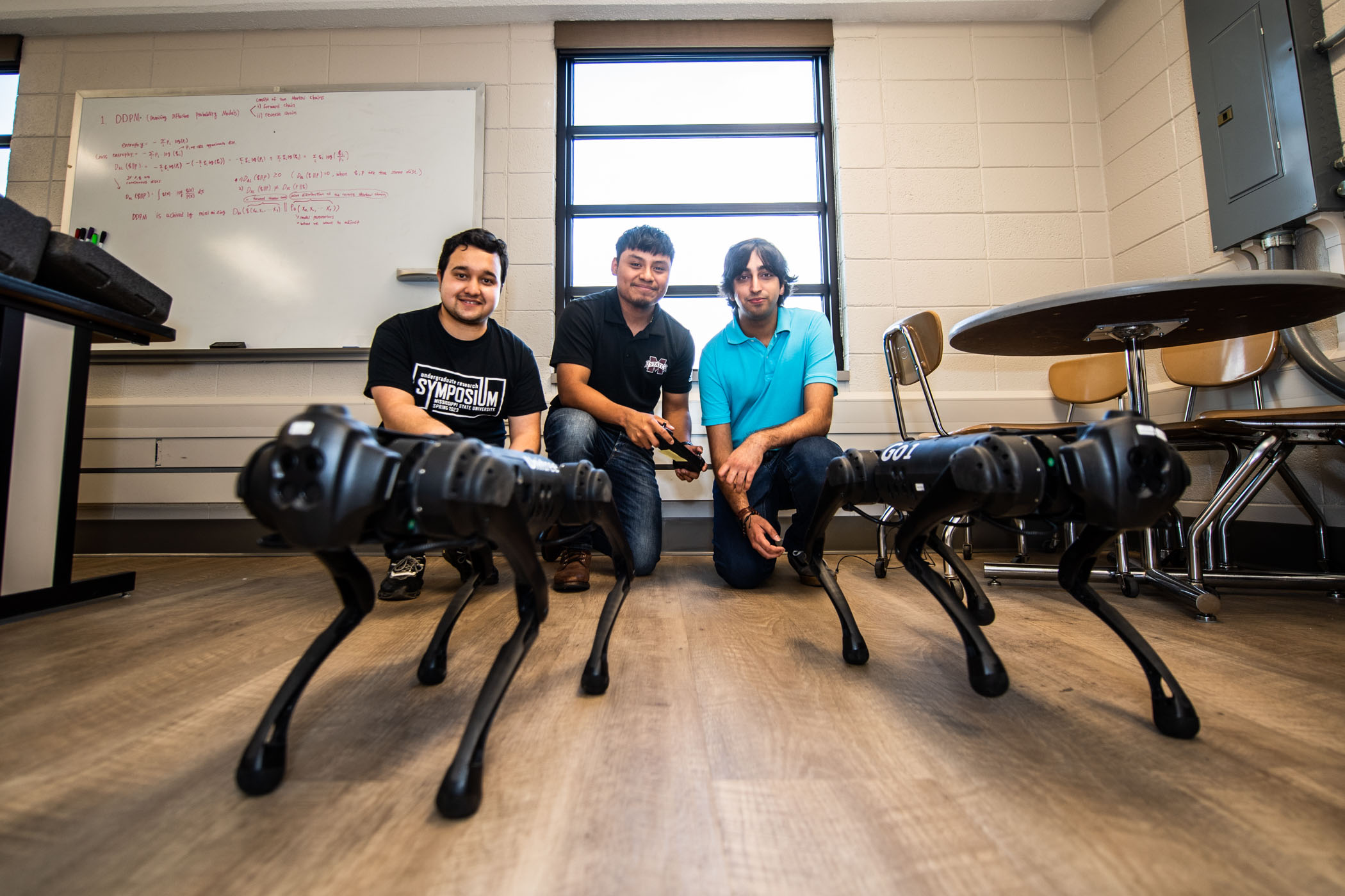 MSU Computer Science and Engineering students (L to R) Arjun Koinkar, Reyki Garcia, and Prabesh Khanal operate the department&#039;s Unitree Go1 quadruped robots