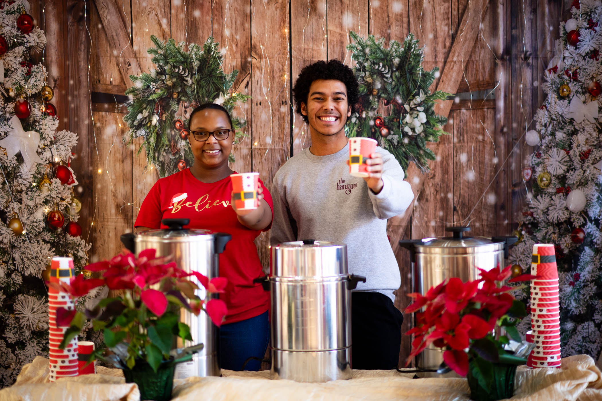 The Graduate School staff Robbie Salters (Left) and Tyrone Tolbert Jr. (Right) service hot cocoa and apple cider to those excited for the holidays at the department&#039;s annual hot coca bar.
