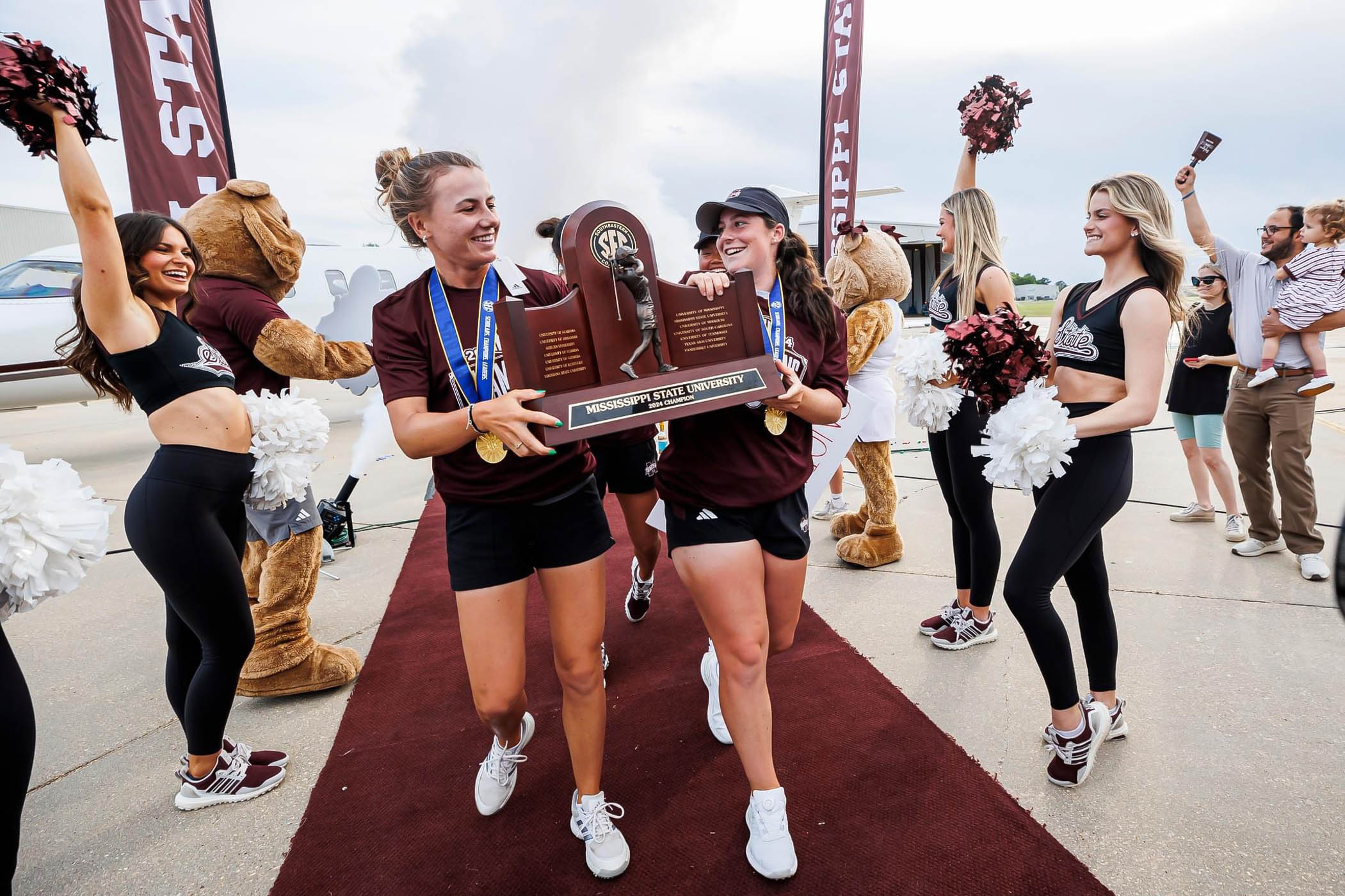 Chiara Horder, (Left,) Avery Weed, (R,) and the rest of Mississippi State&#039;s Women&#039;s Golf team step off walk the maroon carpet as SEC champions for the first time in program history. 