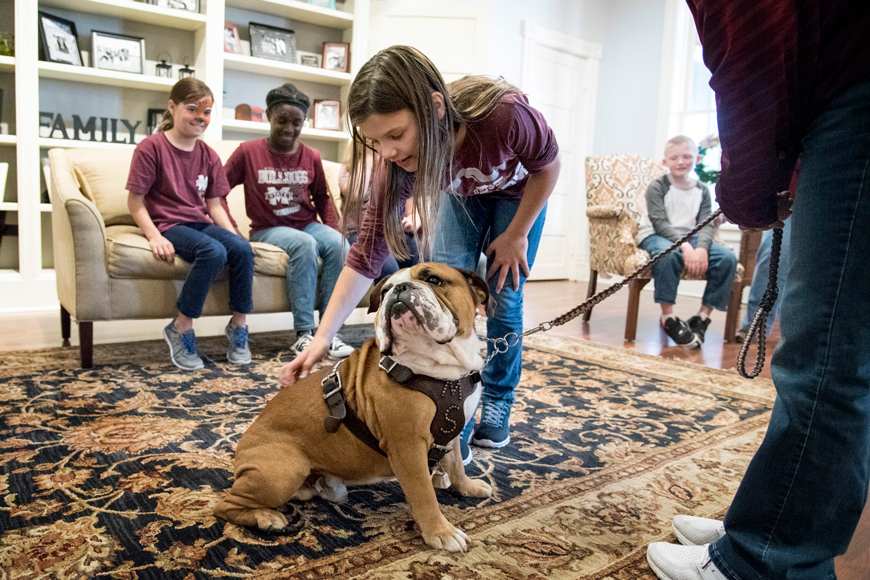 Children at Palmer Home in Columbus take turns petting MSU Bulldog mascot Jak during the College of Veterinary Medicine&amp;#039;s Animals in Focus outreach program.