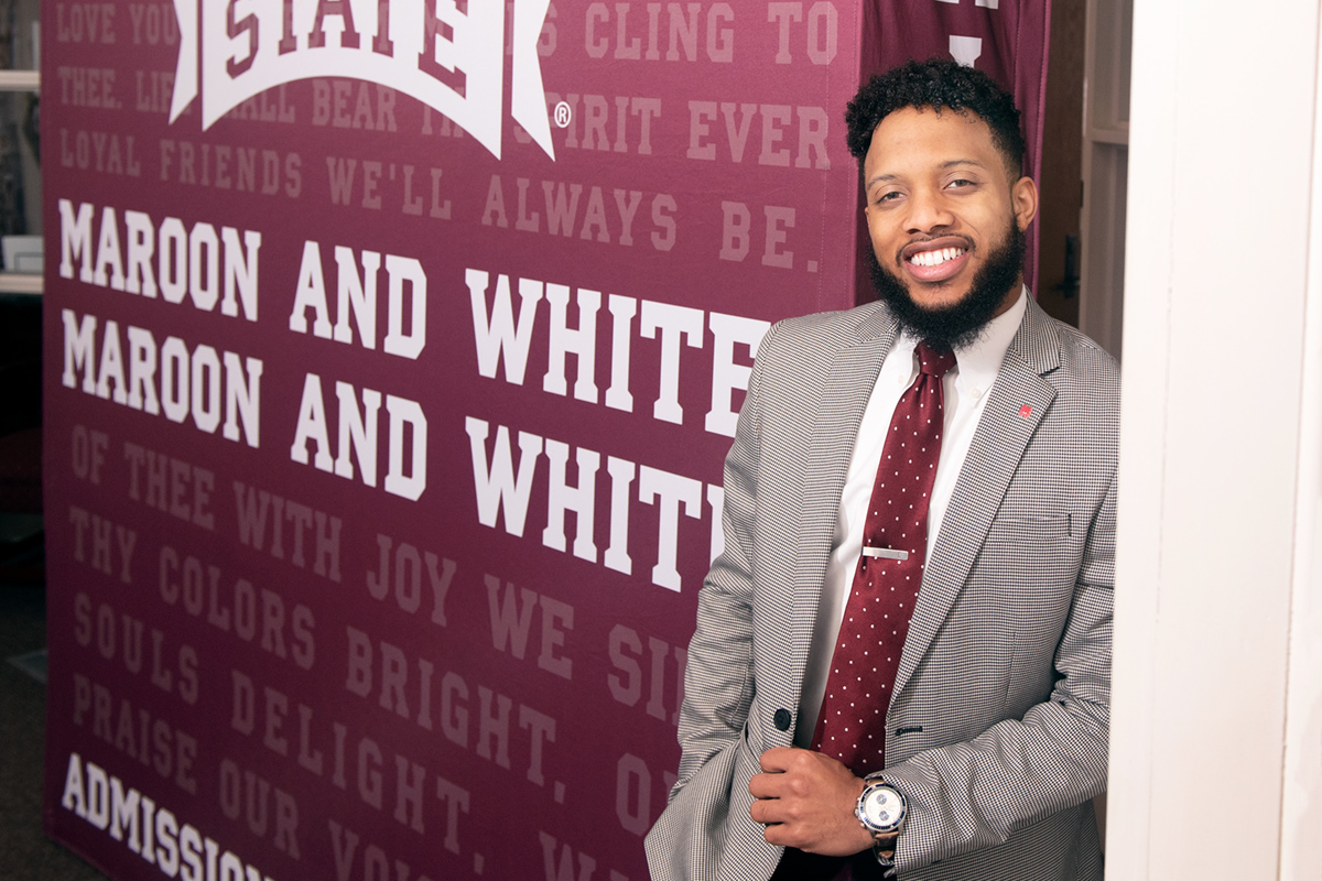 Tabora Cook, pictured in front of an MSU backdrop.