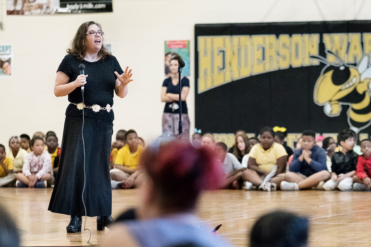 Astronomy professor Donna Pierce speaks with a microphone before assembly of students at Henderson Ward Stewart&amp;#039;s gymnasium.