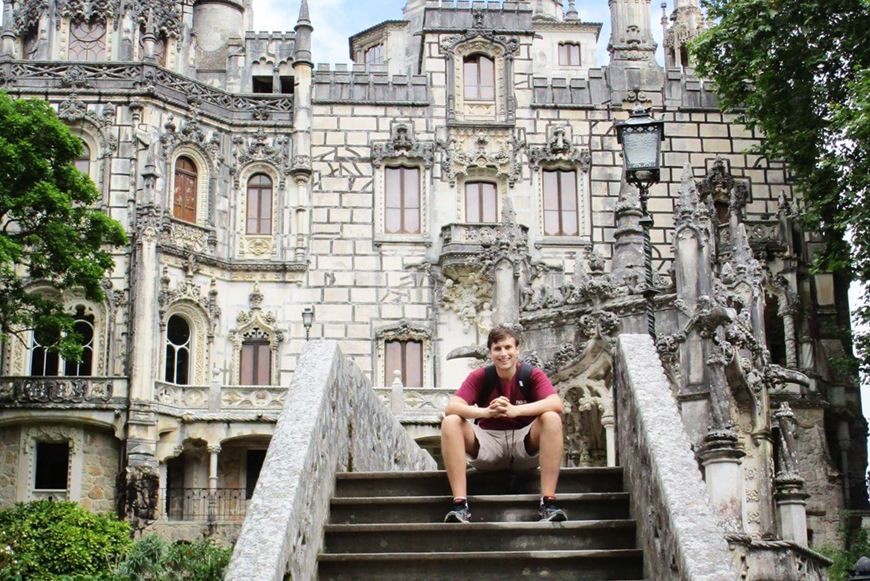 Fletcher Battles sitting on steps in Spain while studying abroad.
