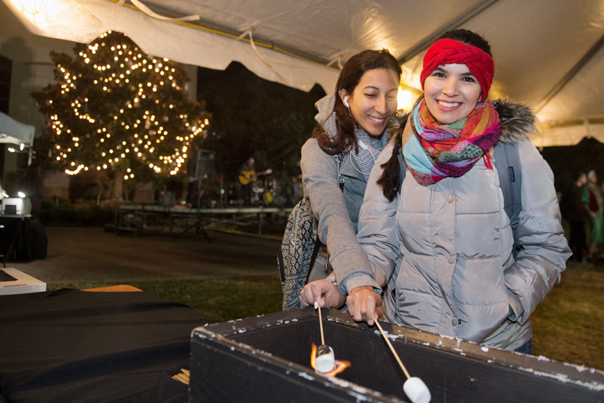 Two female engineering students named Oumnia El Fajri and Lamiae Taoudi roast marshmallows at the Holiday in the Junction smores station