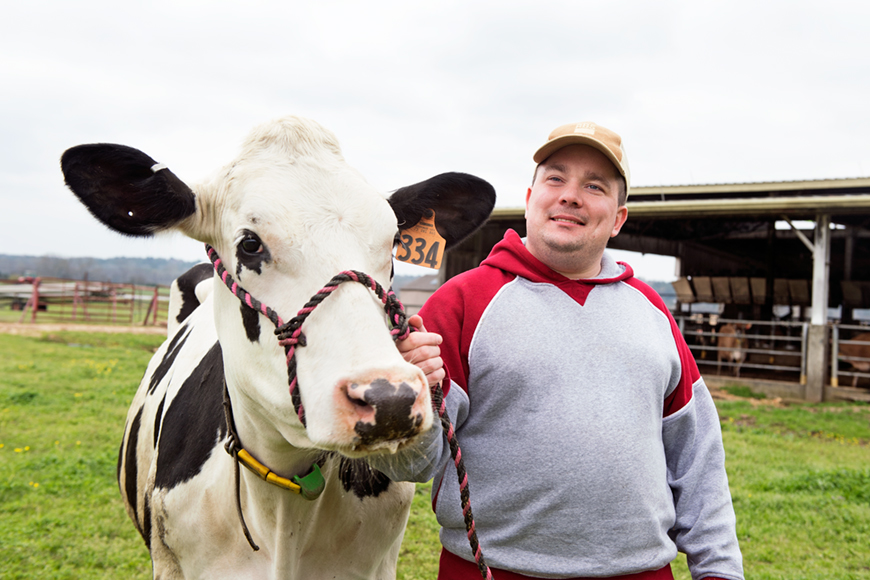 Zachary Mason, pictured outdoors with a cow.