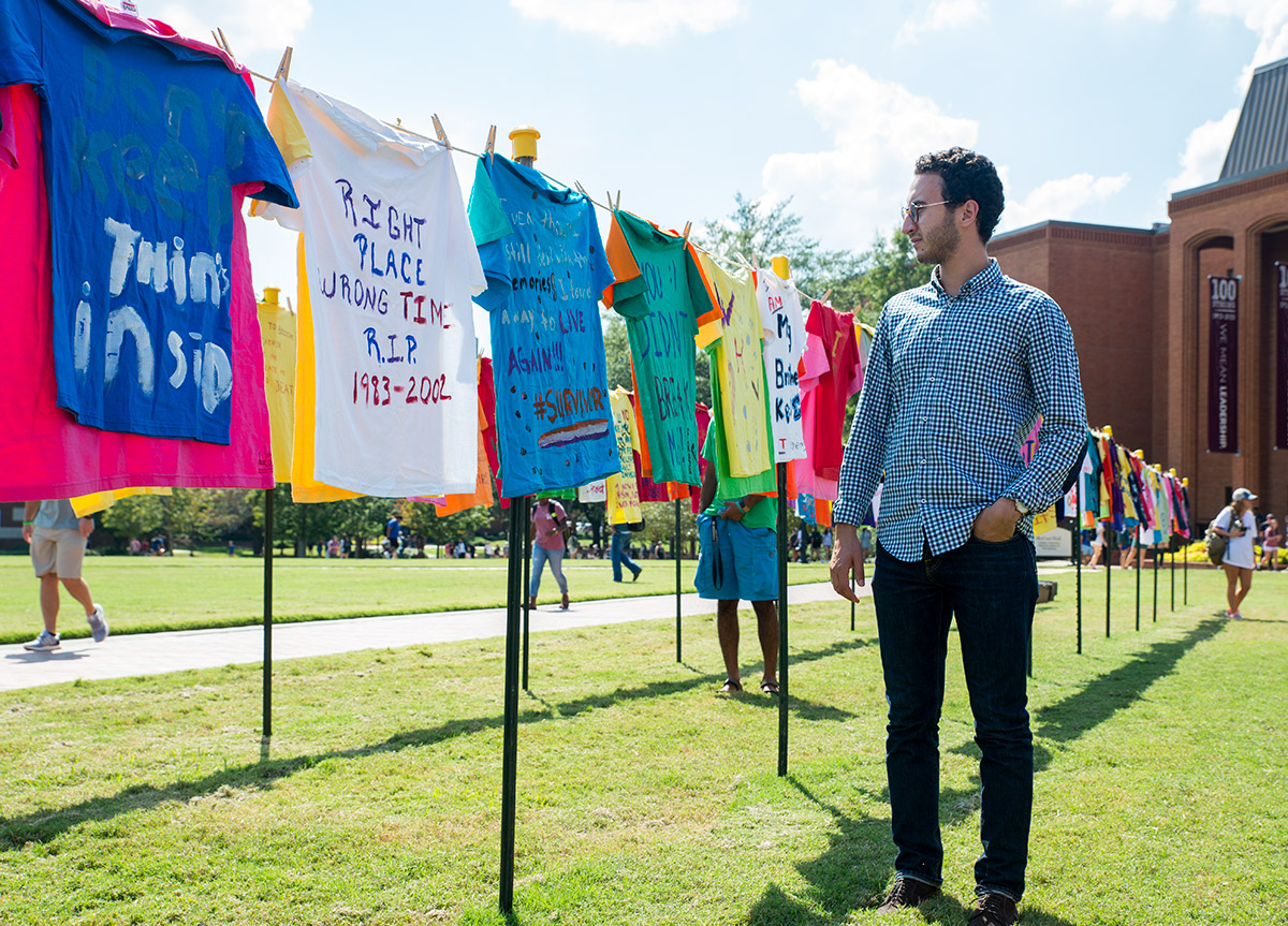 International student observes the Clothesline Project submissions.