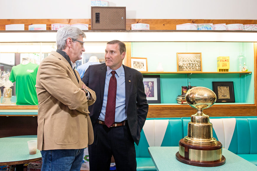 Governor Phil Bryant and Coach Dan Mullen speaking near the Egg Bowl trophy.