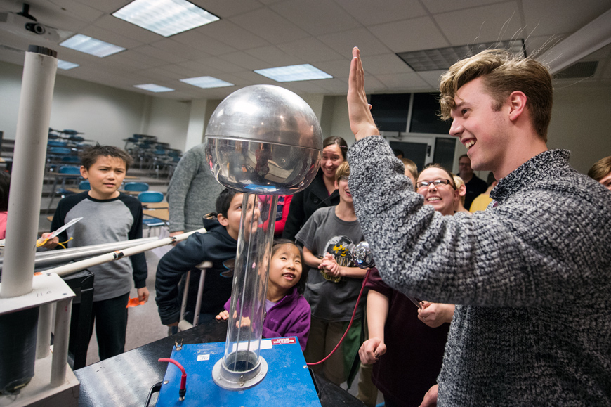 Physics major Randy Niffenegger demonstrates static electricity to a group of amazed children.