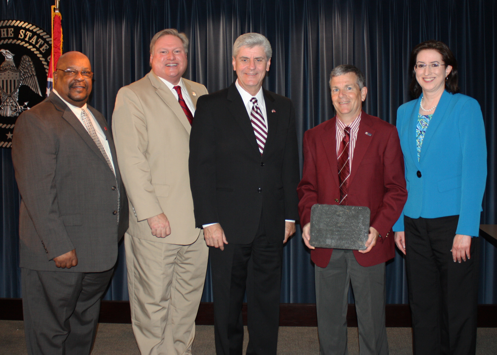 Mississippi State Personnel Board Member Donald Brown, from left, MSPB Chairman Alwyn Luckey, Gov. Phil Bryant, Mississippi State University Director of Procurement and Contracts Don Buffum, and MSPB Executive Director Deanne Mosley.