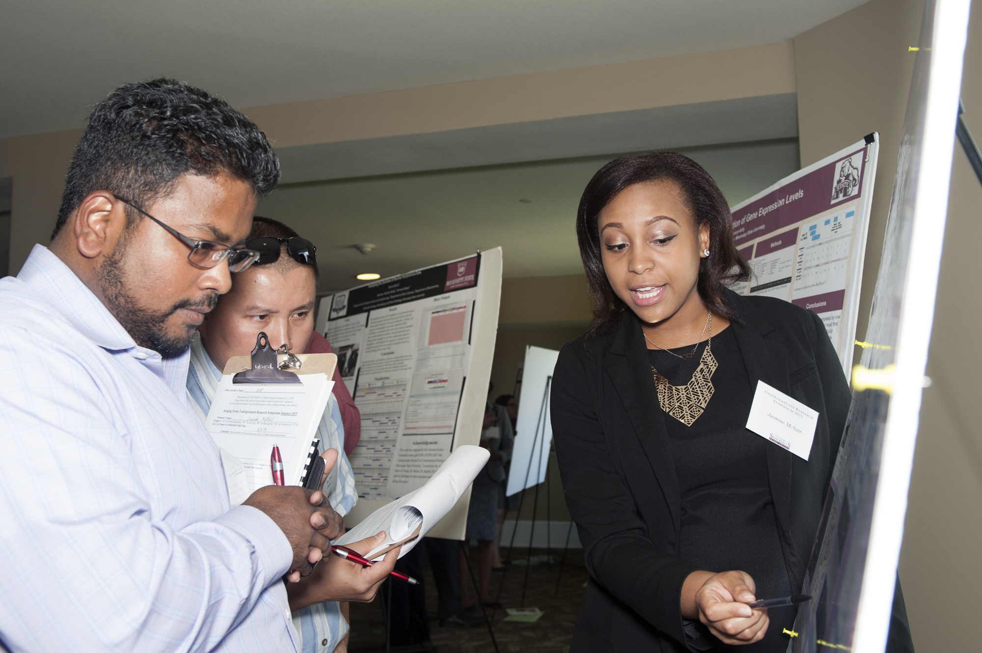 Mississippi State faculty members Raj Prabhu (l) and Thu Dinh look on as freshman Jasmine S. McNair of Ridgeland presented her project during the university's 2015 Undergraduate Summer Research Symposium organized by the Shackouls Honors College. 