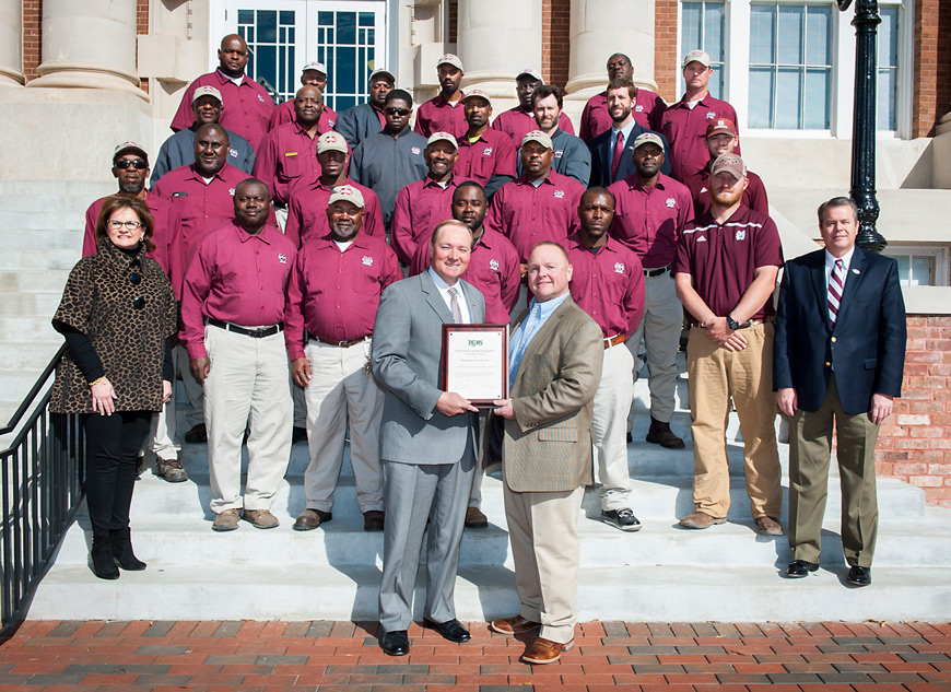 MSU Campus Landscape staff are pictured with administrators congratulating them for national recognition by the Professional Grounds Management Society. MSU President Keenum (front left) receives a plaque from Bart Prather, associate director of campus landscape. Also pictured are (second row) Amy Tuck, vice president for campus services and George Davis, executive director for campus services; (third row) Victor Fulton, Randolph Calmes, Jimmy Colvin, Melvin Turnipseed, Dashun Blair, Alex Miller; (fourth row) John Rice, James Blair, Willie Neely, Shawn Higgins, Sammy Vaughn, Brandon Hardin; (fifth row) Johnnie Turnipseed, Jimmy Rice, Ivan Harris, Will Lawrence, John Copeland, Dan Whatley; (sixth row) Robert Sawyer, Zeb Rice, Edwin Lindsey, Anthony Johnson, Frank Fulton, Jerry Outlaw and Joey Boutwell. Not pictured are Scott Bolton and Perry Sellars. (Photo by Russ Houston)