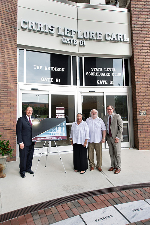 MSU President Mark E. Keenum, left, and Athletics Director John Cohen, right, stand with Margaret and Fred Carl Jr. under the new name of the Davis Wade Stadium gate that now bears the name of the Carls’ late son, Chris. 