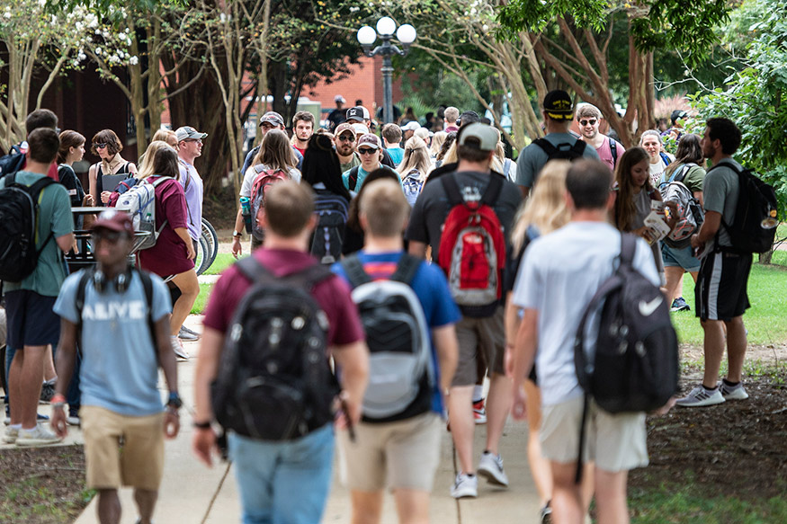 A crowd of students make their way to classes on a walkway beside MSU's historic Drill Field on the first day of the fall semester.