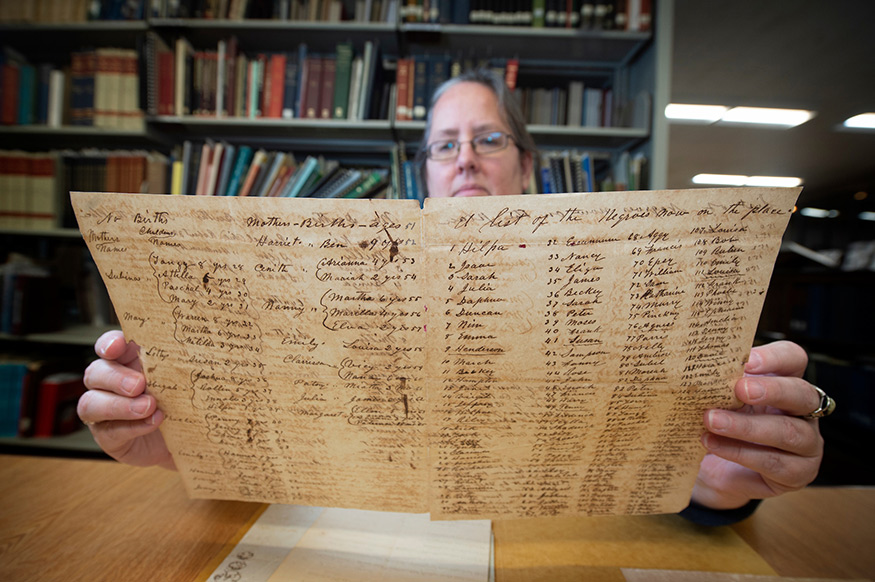 Jennifer McGillan, program director for the Lantern Project, looks over a historical document