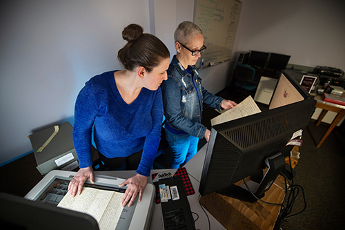 Emily D. Harrison, left, works with Jenifer Ishee to digitize a document for the Lantern Project. 