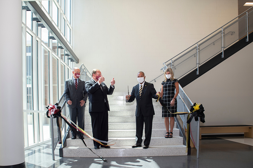 Administrators cut a ribbon in the atrium of the Partnership Middle School