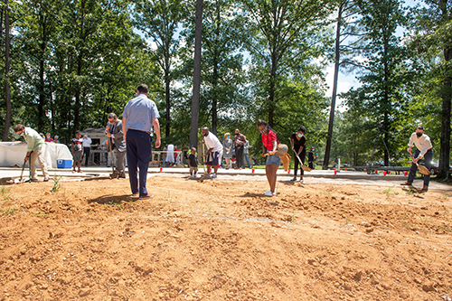 Attendees turn dirt during a Monday [Aug. 3] groundbreaking ceremony at the site of the 12th annual Maroon Edition home.