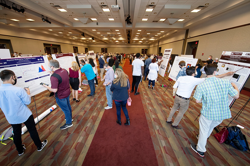 An overhead view of students and judges looking at research posters in Colvard Student Union's Foster Ballroom during MSU's Summer Undergraduate Research Symposium