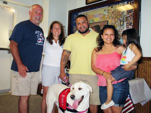 George Gomez, center, and his dog “Trinity,” were brought together by the Pets for Vets program after the dog was rescued from abandonment through the Homeward Bound program based at Mississippi State University’s College of Veterinary Medicine. Pictured at a “Stand for the Troops” recent event are (left to right) Tony Cataldo, who fostered Trinity before her adoption, ROAR Director Allyson Dotson, Gomez and his wife Claudia with their daughter Genesis. (Photo submitted)