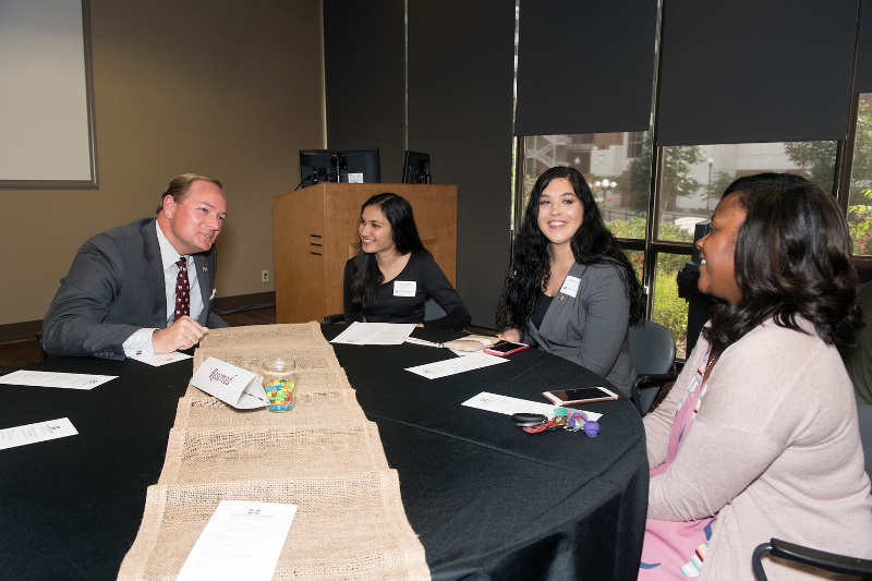 MSU President Mark E. Keenum visits with Promise Program students Roshni Patel, Brittany Stansel and Jasmine Daniels during an Aug. 23 ice cream social. (Photo by Beth Wynn)