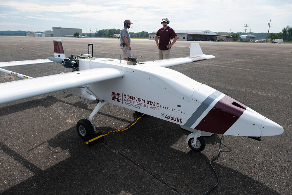Raspet personnel prepare to fly an unmanned aircraft on an airport runway.