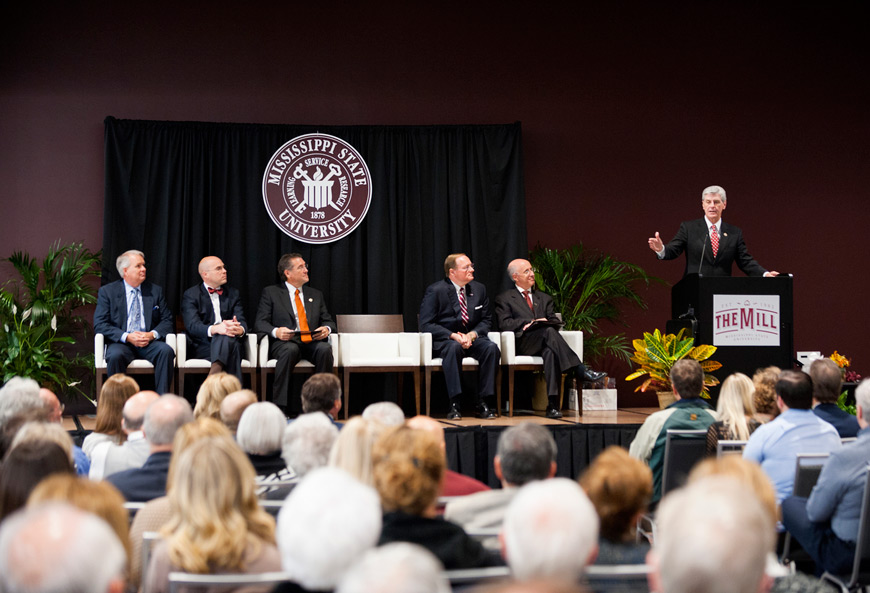 Gov. Phil Bryant (right) speaks during the official grand opening of The Mill at MSU on Monday [Oct. 19]. Joining him on the stage are developer Mark Castleberry (l-r), Starkville Mayor Parker Wiseman, Third District Congressman Gregg Harper, MSU President Mark E. Keenum and MSU Vice President for Research and Economic Development David Shaw. (Photo by Russ Houston)