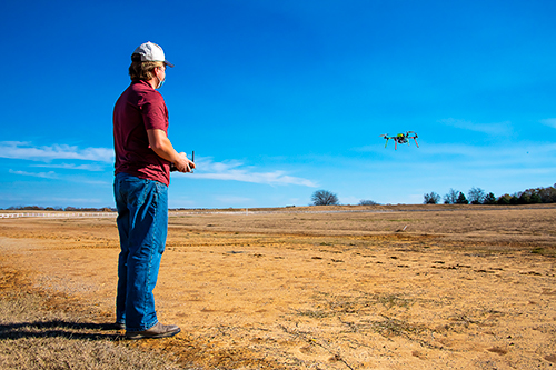 Bryan Whittenton of Forrest City, Arkansas, a plant and soil sciences doctoral student, flies a student-built 650 class rotocopter at the MSU Horse Park. 