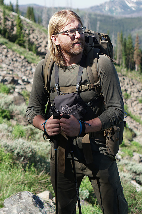 Brandon Barton on a research expedition dressed in hiking gear outdoors. 