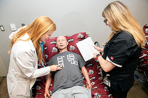 Two assistant clinical professors with MSU-Meridian’s Master of Physician Assistant Studies program, demonstrate patient simulation equipment. 