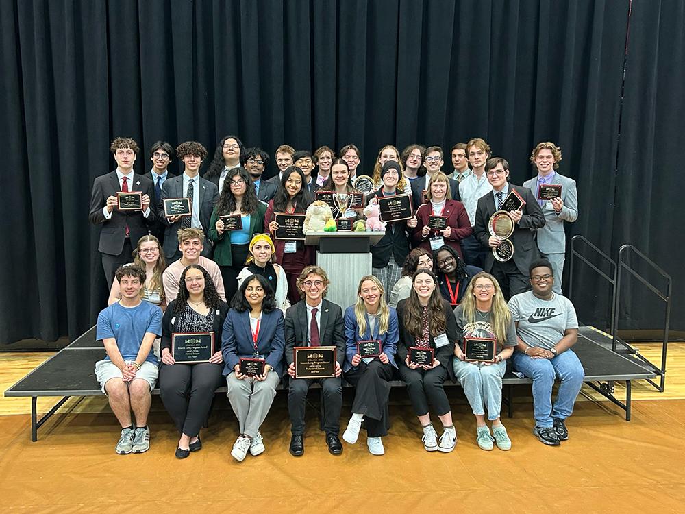 Members of the Mississippi State Debate team pose with group and individual awards after capturing a second-straight national title at April’s International Public Debate Association National Tournament.