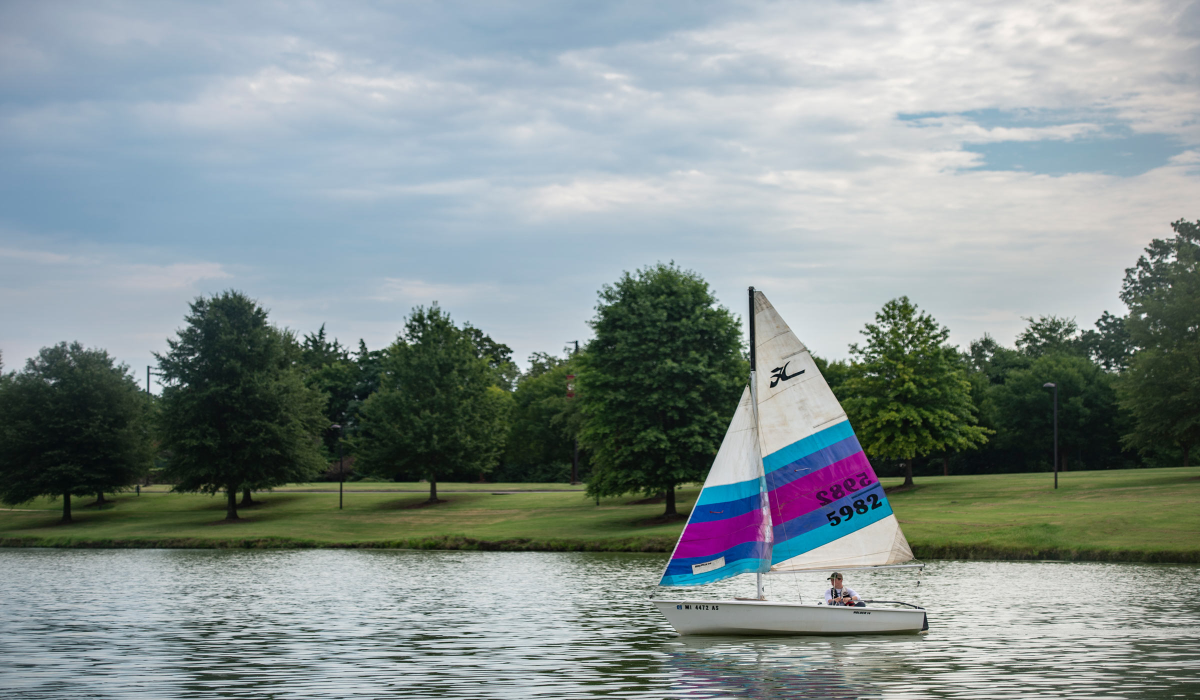 Sam Miller, a recent MSU graduate, takes a sailboat out on Chadwick Lake.