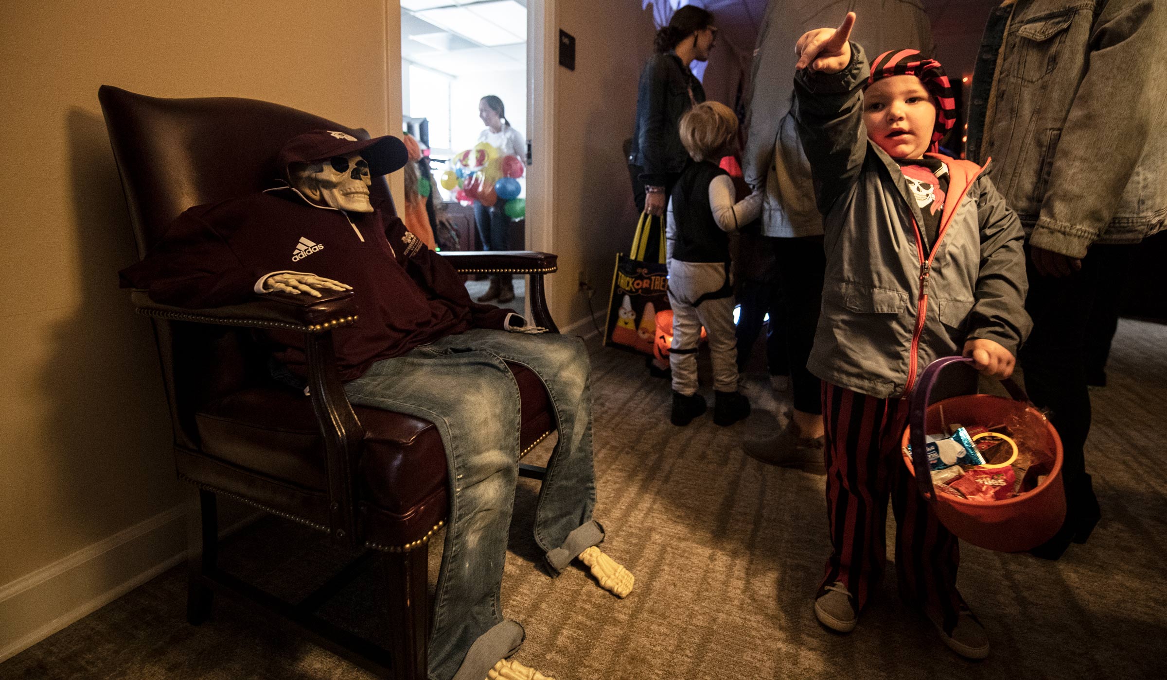 Kyle Lane Livingston points to the Halloween decorations in the graduate school as they trick or treat with faculty, staff and students.