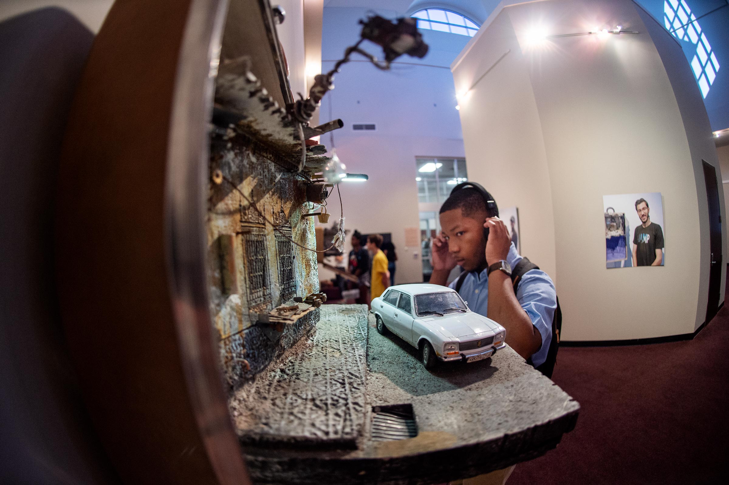 With the details of a suitcase diorama in the foreground, art major Christian Ivy listens to one of the audio clips accompanying the UNPACKED exhibition.