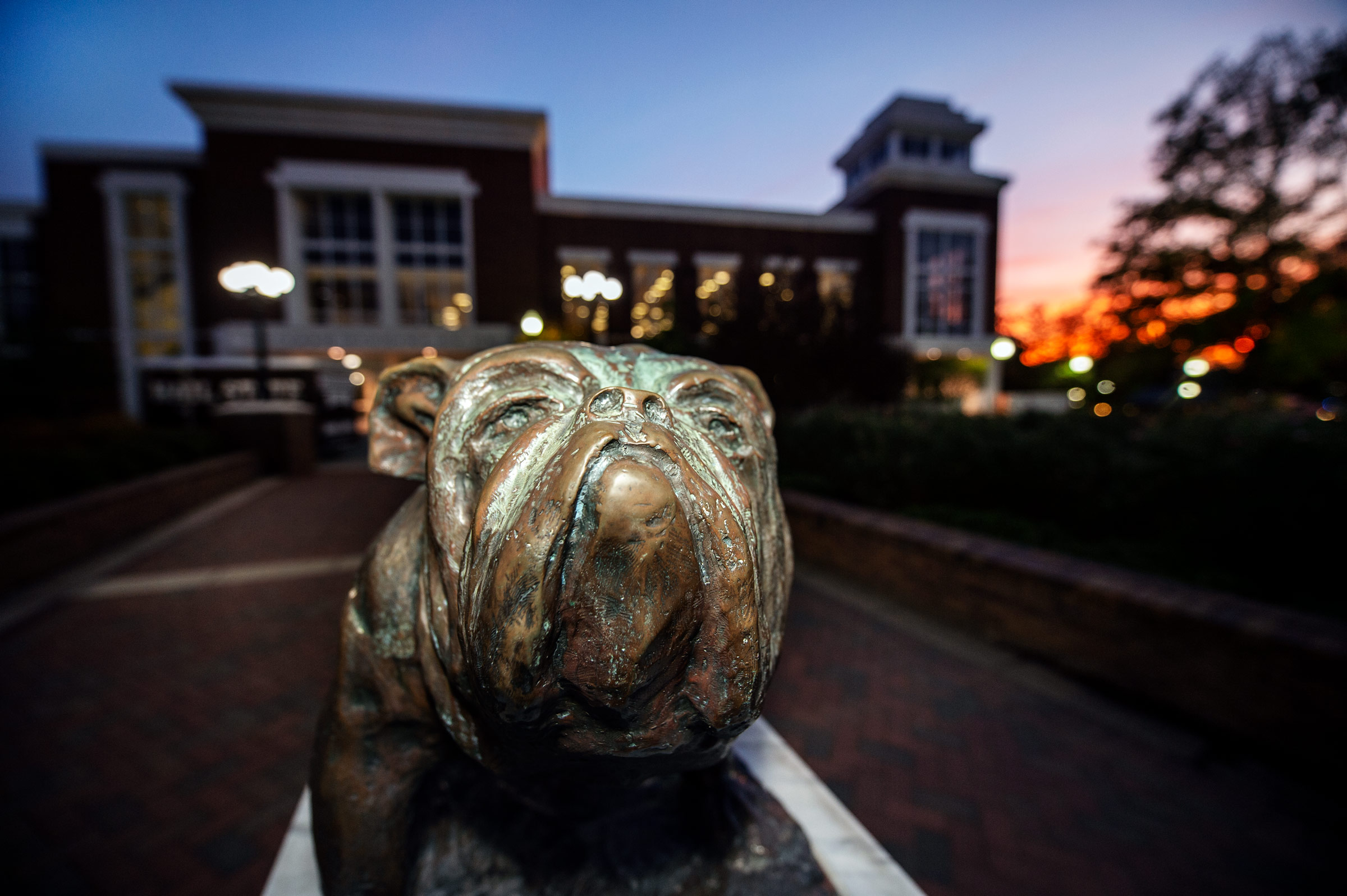The Colvard Union Bully fills the foreground, with the building and fall sunset behind.