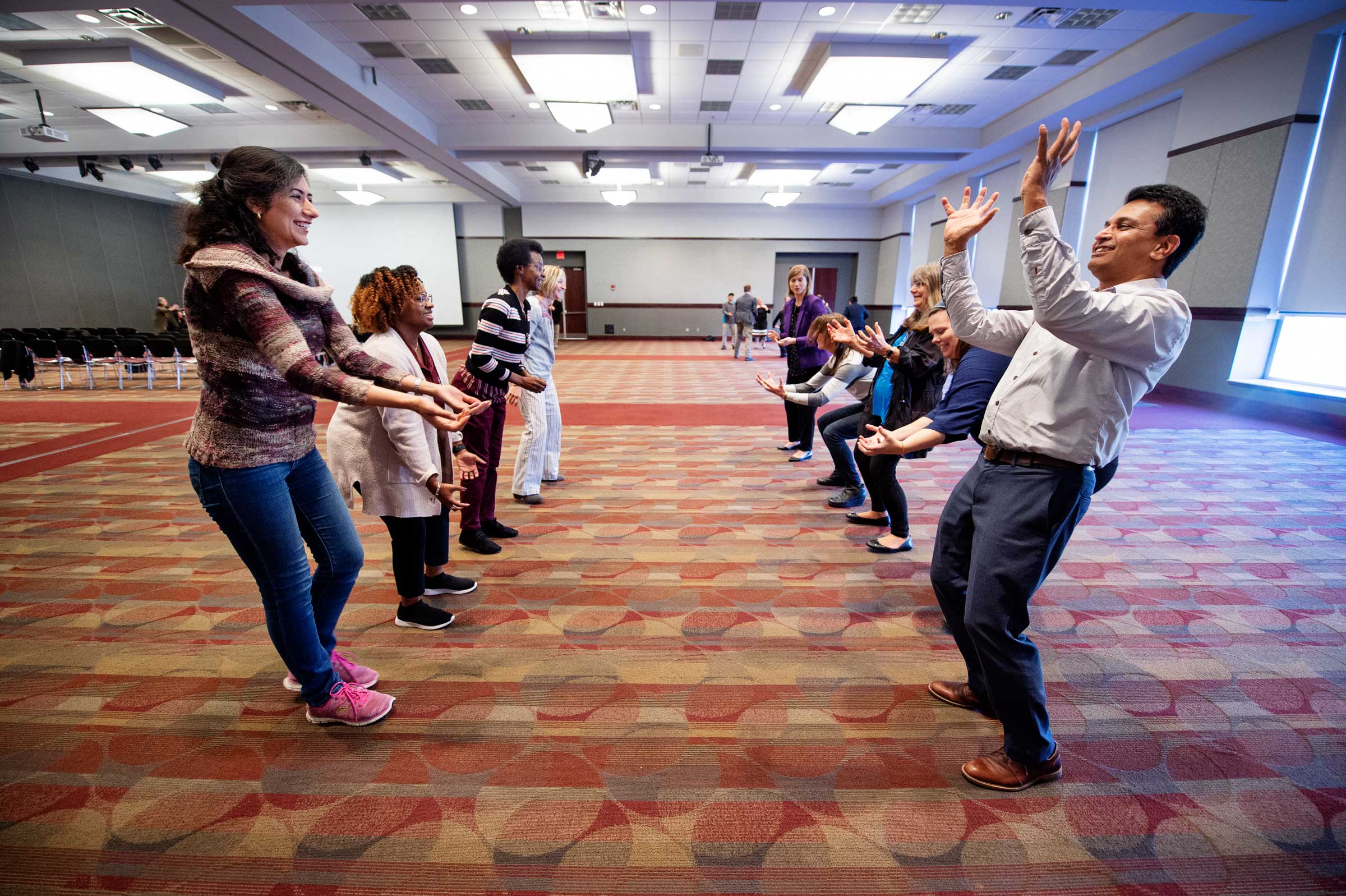 Two rows of MSU faculty practice improv skills as part of a workshop on communicating science.