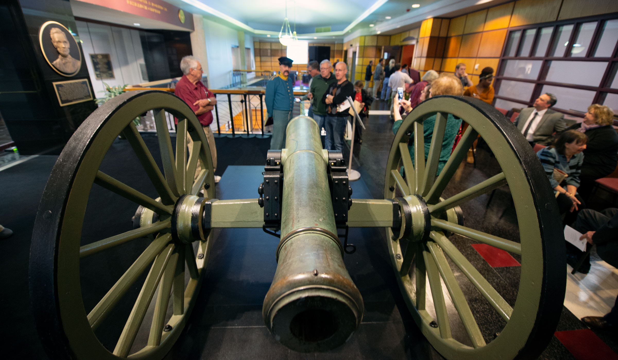 With the freshly unveiled 19th Century cannon in the foreground, Library visitors admire the new addition.