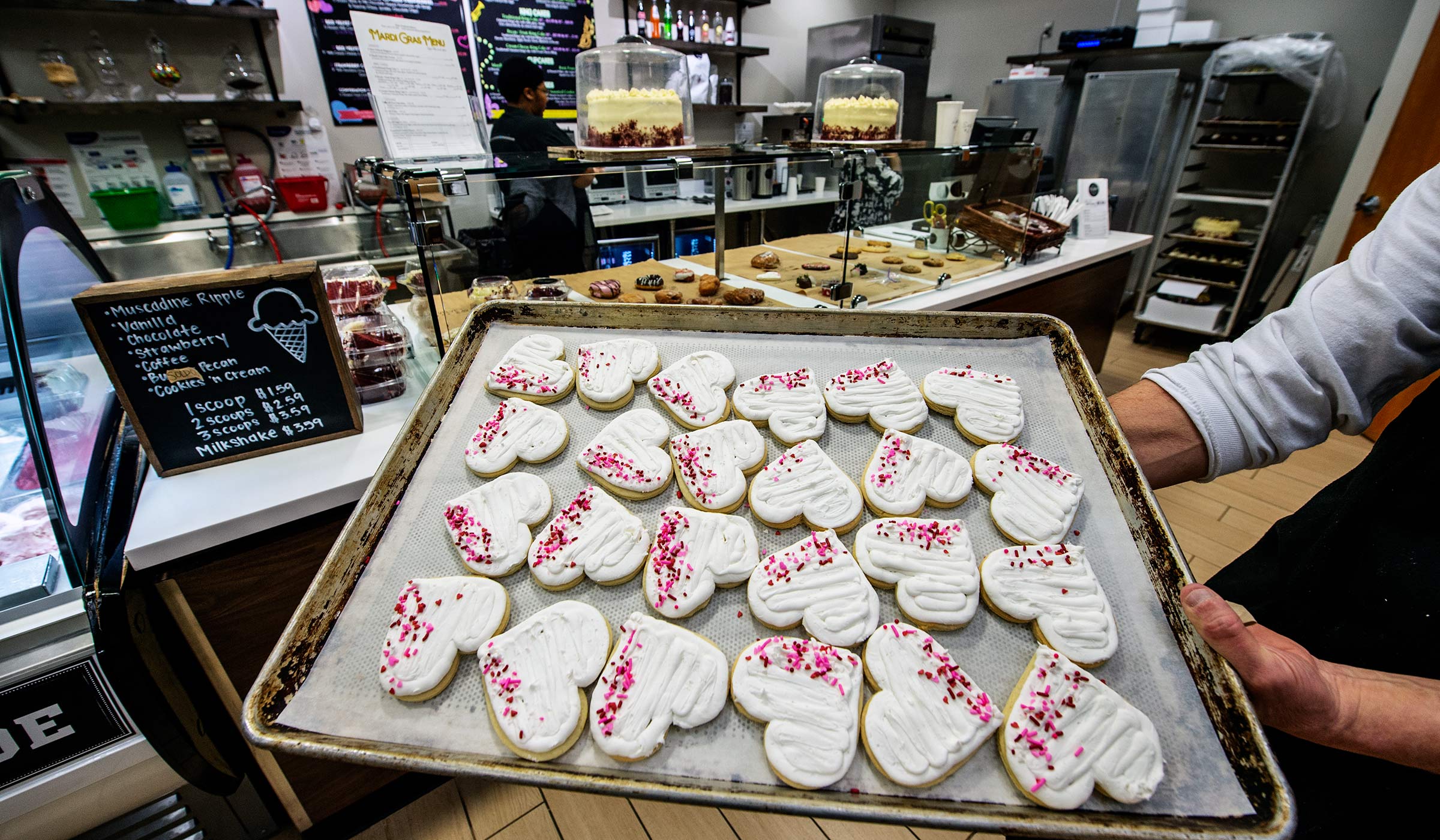 Heart shaped cookies held in the foreground of the State Fountain Bakery.