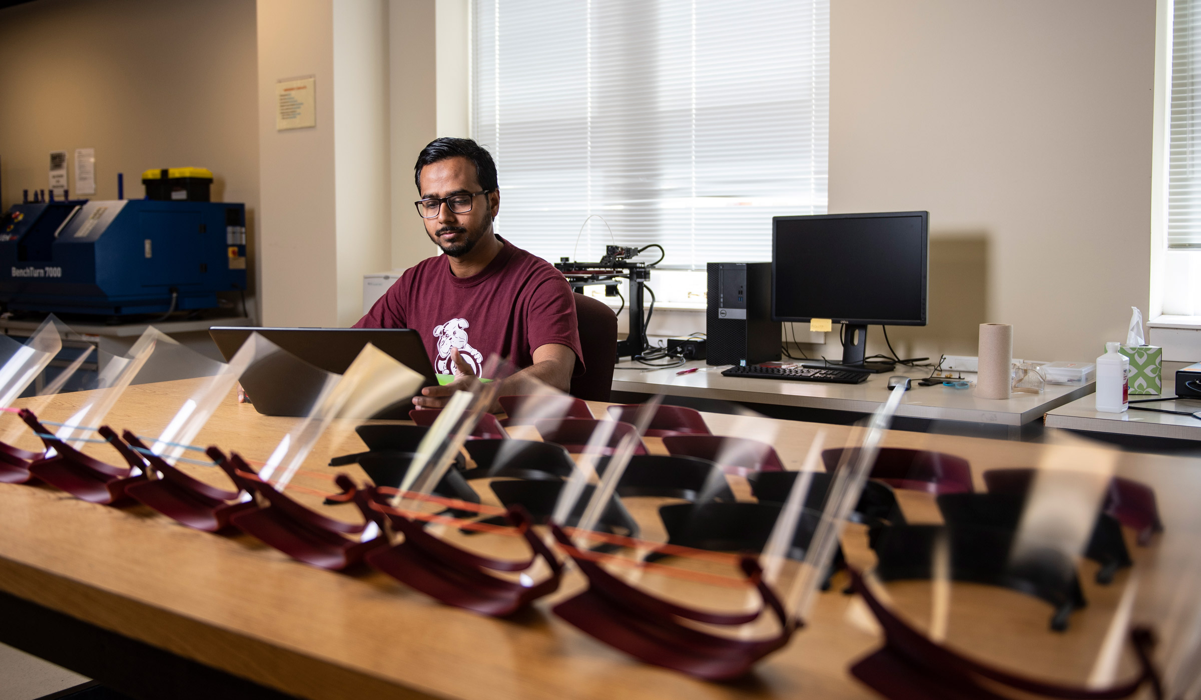 Industrial and systems engineering Ph.D. student Abdullah Al Mamun of Bangladesh monitors the production of face shields by an MSU team making their first set for health care facilities in Meridian. Using 3D printers and basic office supplies, the engineers and researchers are manufacturing 250 of the face protectors per week to be delivered to medical professionals caring for patients with coronavirus.  