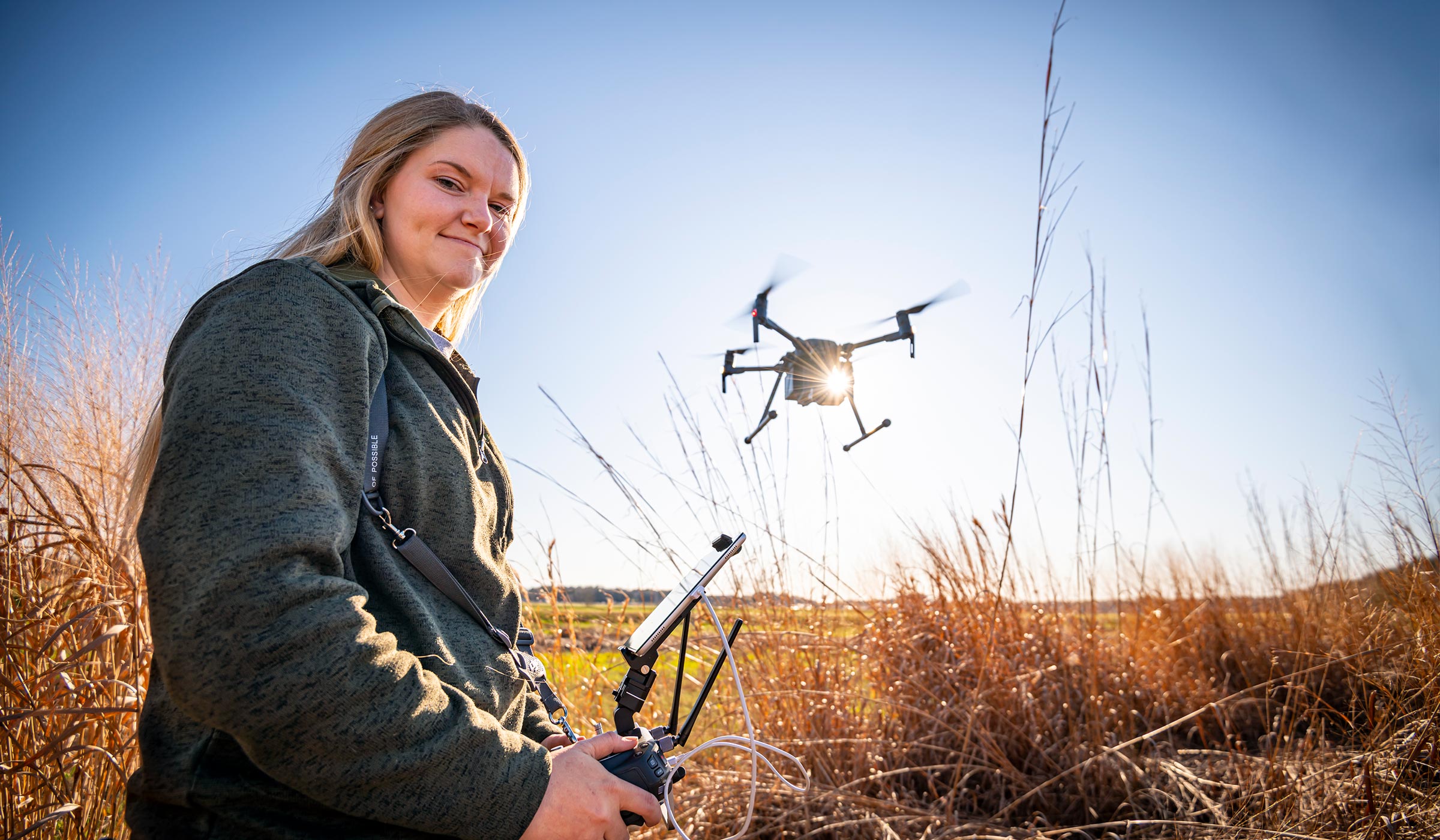 Lori Hearon, pictured flying a drone in an open field.