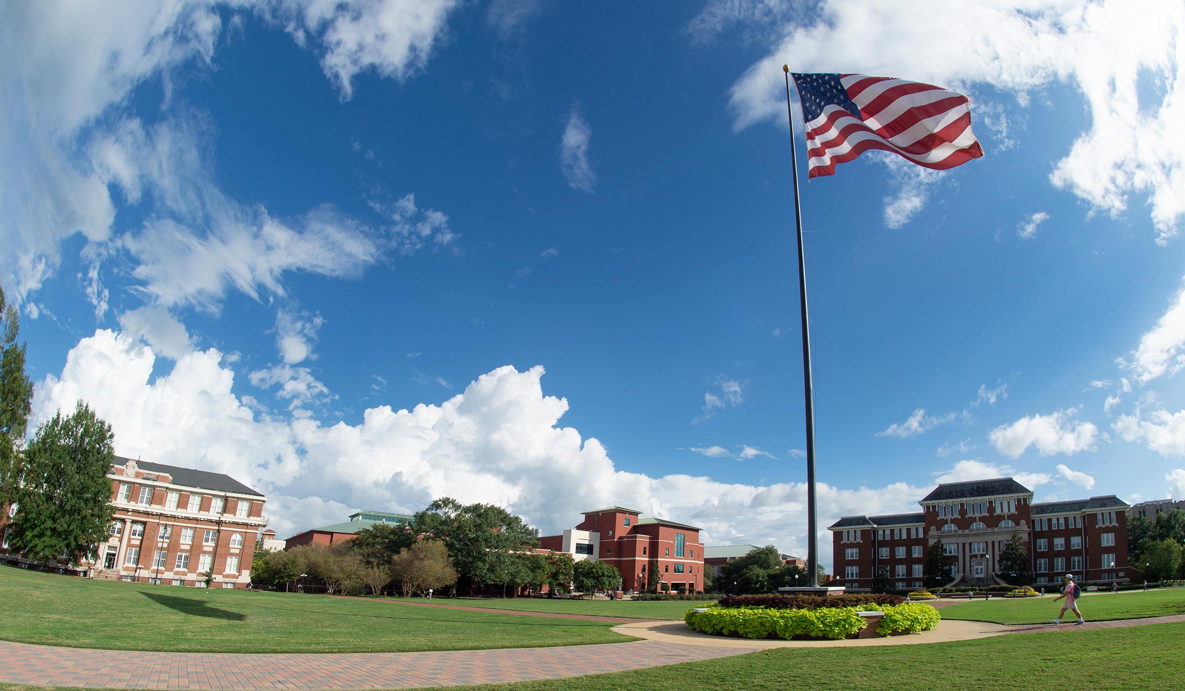 Blue sky with puffy clouds and wind blowing American flag