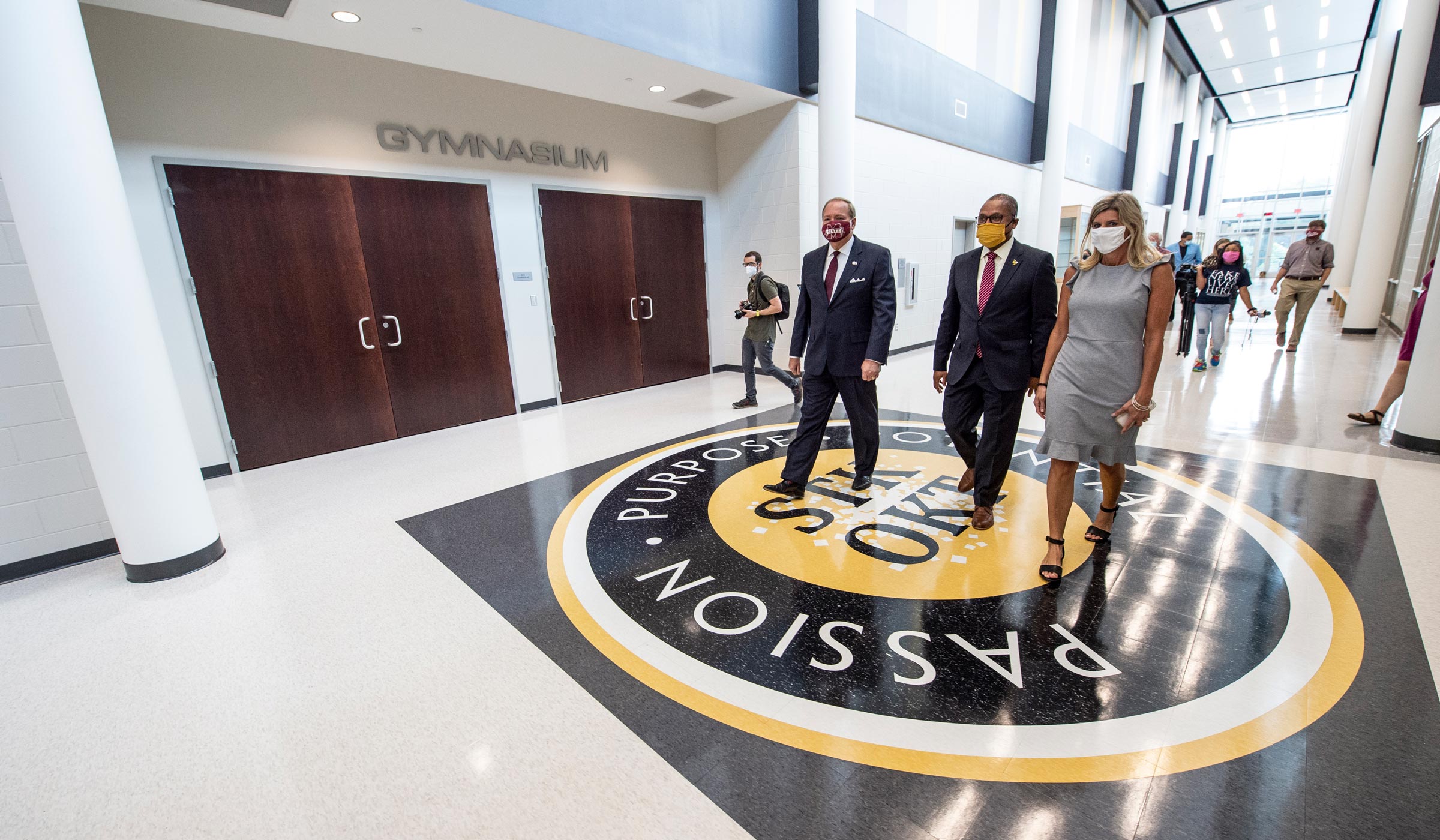 While touring the new MSU-SOSD Partnership School, President Keenum, Superintendant Peasant, and Principal Kennedy walk over a giant Yellow Jackets logo on the hall floor.