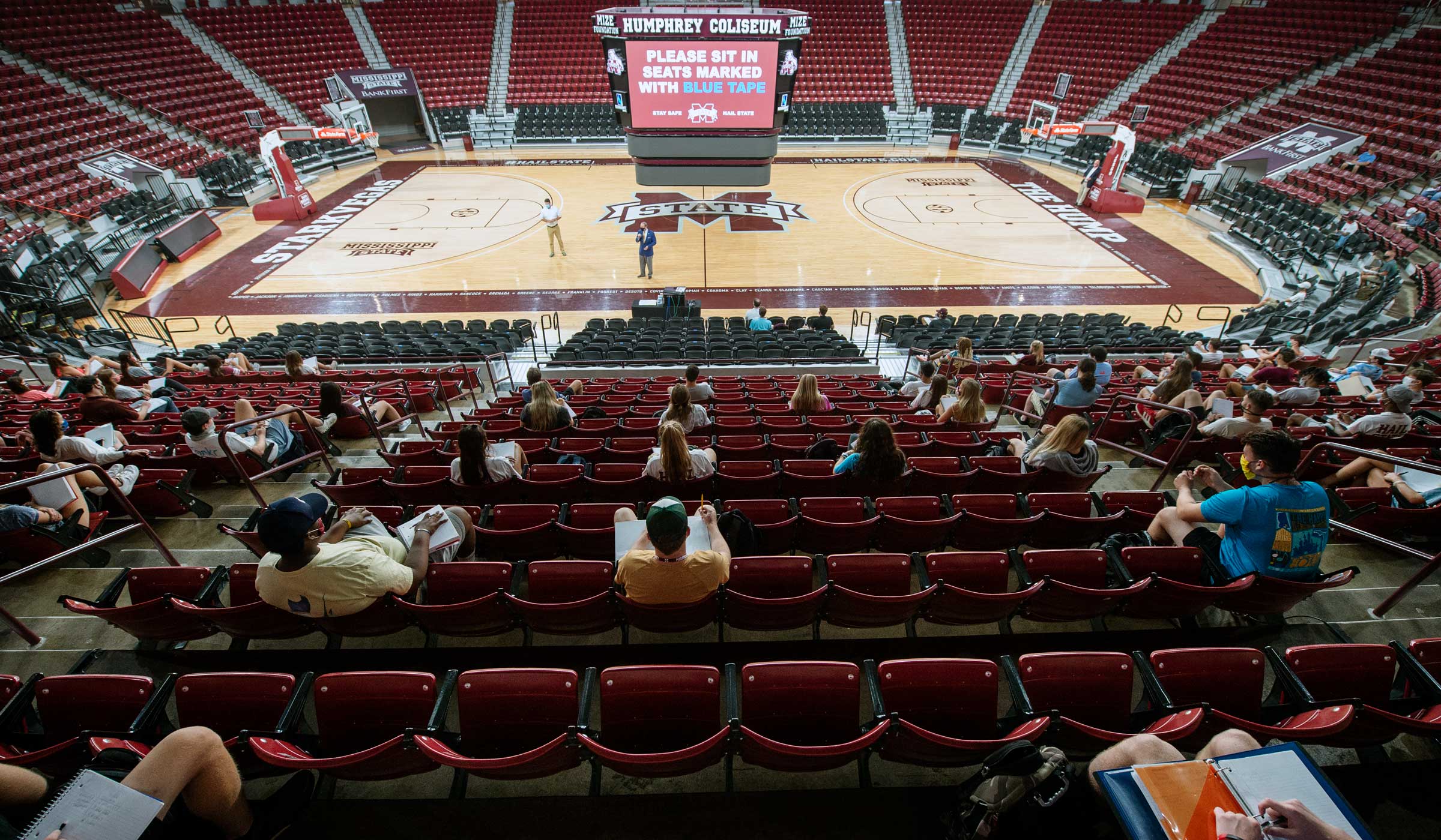 View looking down on American Government class in the Hump, with President Keenum and Faculty Whit Waide addressing students distanced in seats.